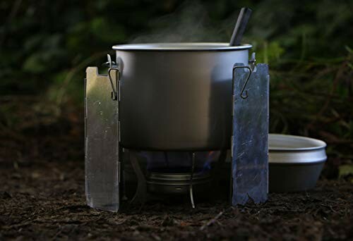 Camping cookware on a portable stove with a pot and lid.