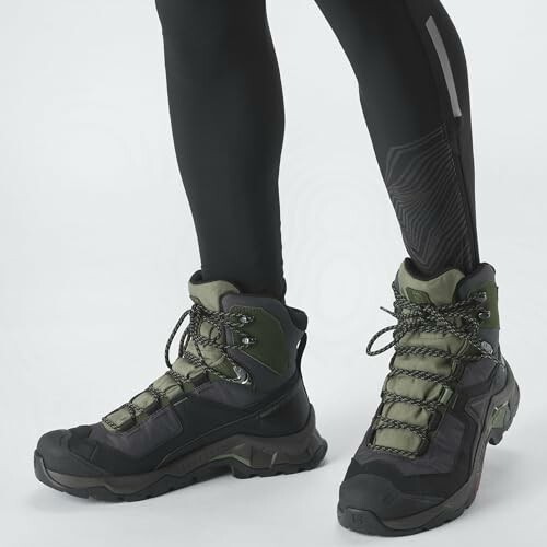 Person wearing hiking boots and black leggings